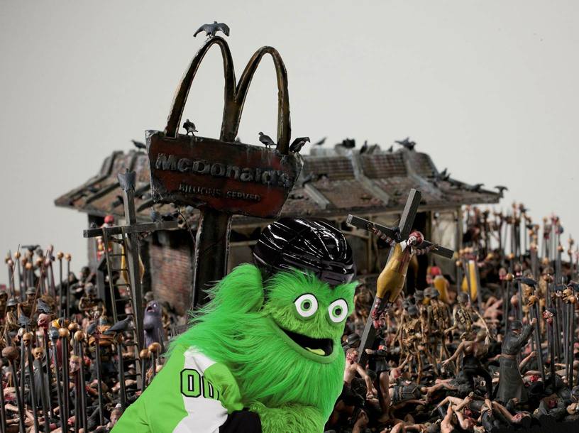 Green Gritty in front of McDonald’s hellscape